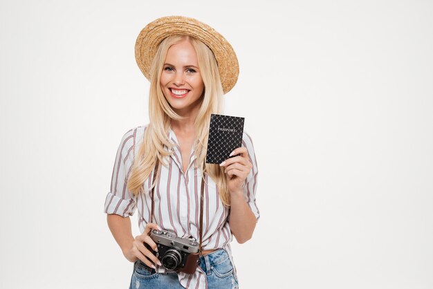 Porträt einer glücklichen jungen Frau im Hut, der Kamera hält