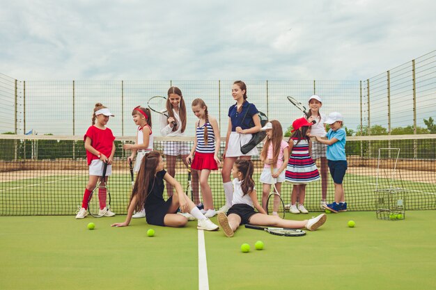 Porträt einer Gruppe von Mädchen als Tennisspieler, die Tennisschläger halten