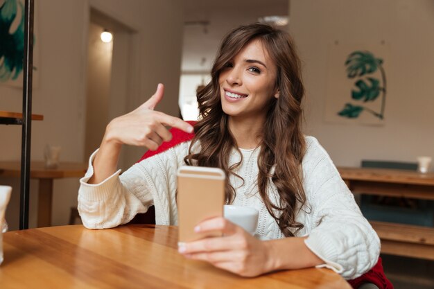 Porträt einer heitren Frau, die Finger zeigt