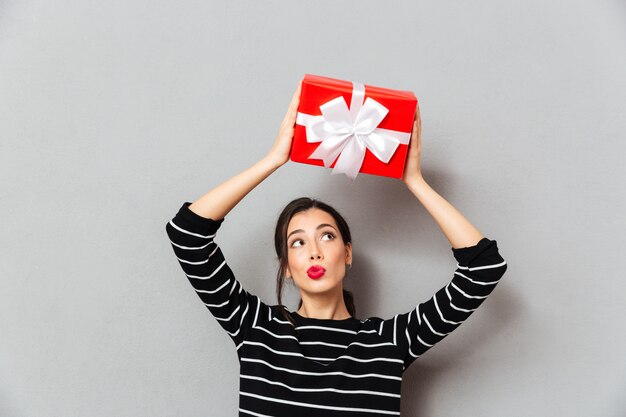 Porträt einer hübschen Frau, die Geschenkbox hält