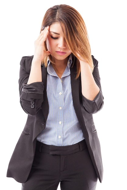 Porträt einer hübschen Geschäftsfrau, die ihre Schläfe berührt und sich von so viel Arbeit und Stress überwältigt fühlt