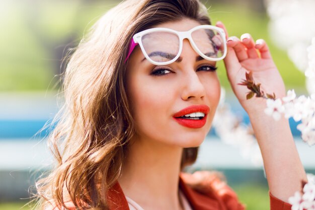 Porträt einer hübschen sinnlichen hellen Frau mit erstaunlichen roten Lippen, die coole Brille tragen