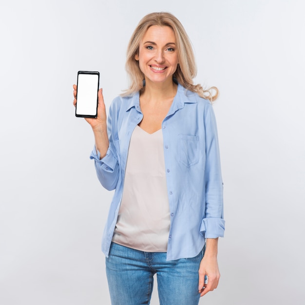 Porträt einer jungen Blondine, welche die Kamera zeigt Handy mit leerem weißem Bildschirm betrachtet