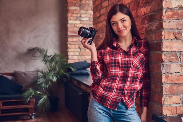 Porträt einer jungen Fotografin in Flanellhemd und j