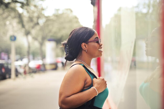 Porträt einer jungen Frau auf der Straße beim Betrachten eines Schaufensters