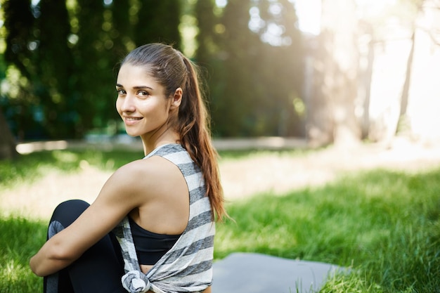 Porträt einer jungen Frau, die an einem sonnigen Sommertag ihren Yoga-Kurs im Park genießt