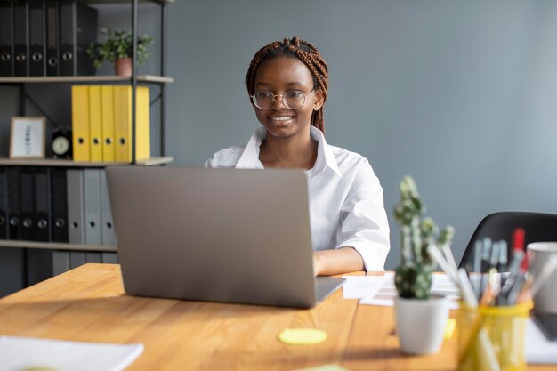 Porträt einer jungen Frau, die an ihrem Laptop in einem Startup-Unternehmen arbeitet