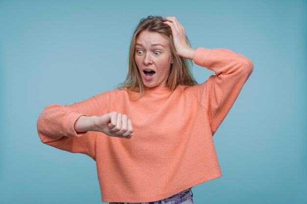 Porträt einer jungen Frau, die auf ihre Uhr schaut