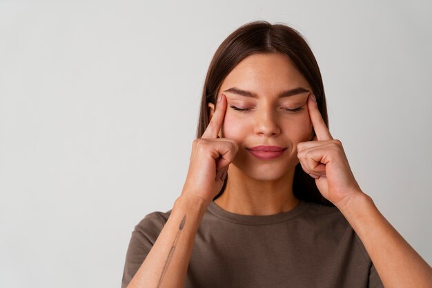 Porträt einer jungen Frau, die Gesichtsyoga für Jugendliche praktiziert