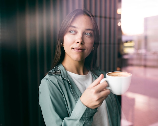 Porträt einer jungen Frau, die Kaffee genießt