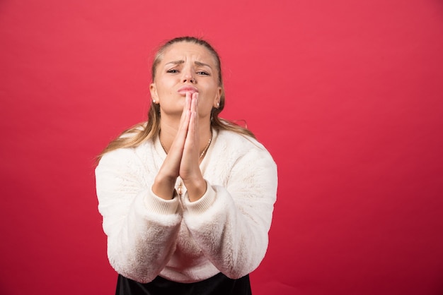 Kostenloses Foto porträt einer jungen frau, die zusammenpressende handflächen betteln betteln, um hilfe beten