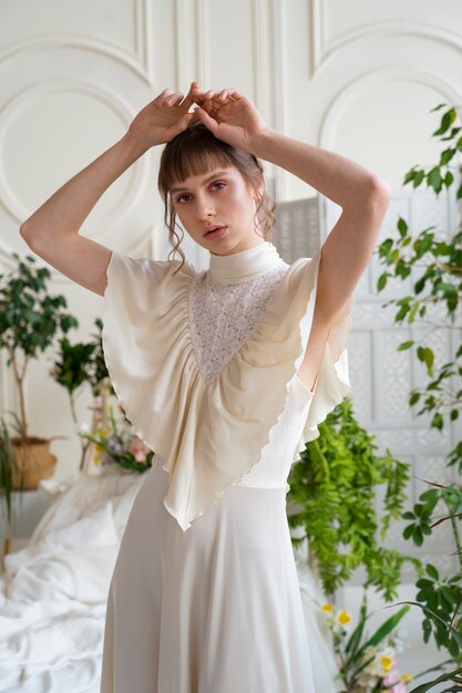 Porträt einer jungen Frau im Boho-Kleid mit romantischer Gartenästhetik und Vegetation