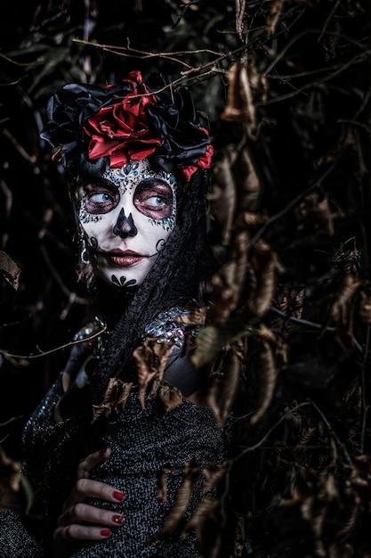 Porträt einer jungen Frau im Stil des mexikanischen Feiertags Tag der Toten