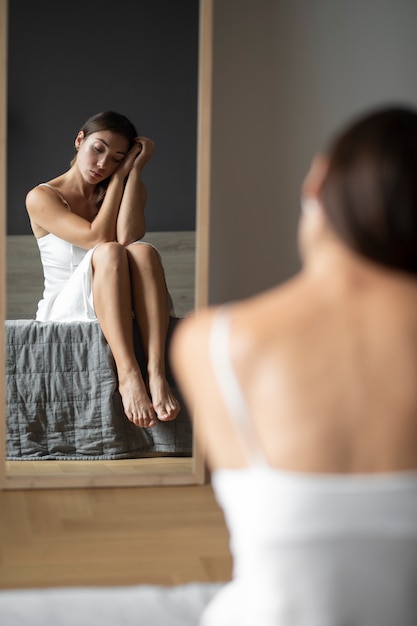 Porträt einer jungen Frau mit geringem Selbstwertgefühl mit Spiegel