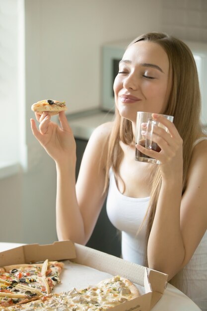 Porträt einer jungen Frau mit Pizza in der Hand