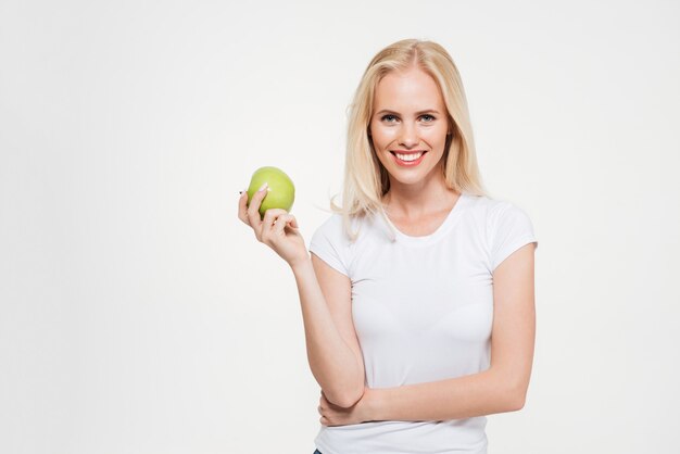 Porträt einer jungen gesunden Frau, die grünen Apfel hält