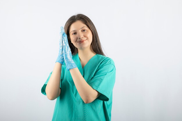 Porträt einer jungen Krankenschwester oder eines Doktors in der grünen Uniformaufstellung.