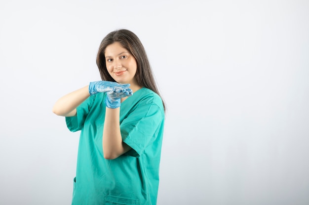 Porträt einer jungen Krankenschwester oder eines Doktors in der grünen Uniformaufstellung.