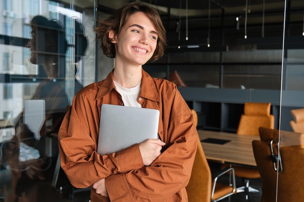 Porträt einer jungen Managerin im Büro mit einem Laptop-Digitalnomaden-Programmierer, der bei ihr arbeitet