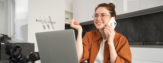 Kostenloses Foto porträt einer jungen selbstständigen unternehmerin, die von zu hause aus arbeitet freelancer, die ein kundenmädchen anruft