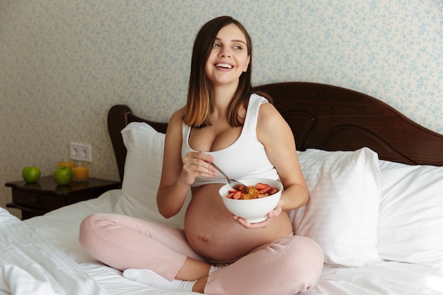 Porträt einer lachenden jungen schwangeren Frau