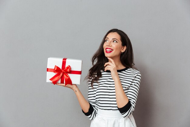 Porträt einer lächelnden Frau, die Geschenkbox hält