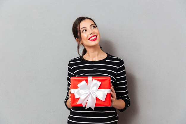 Porträt einer lächelnden Frau, die Geschenkbox hält