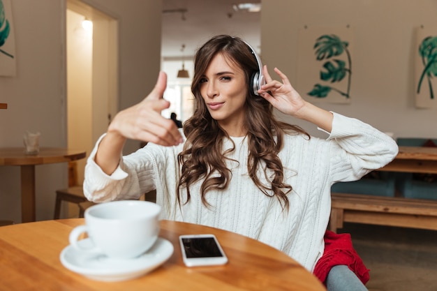 Porträt einer lächelnden Frau, die Musik hört