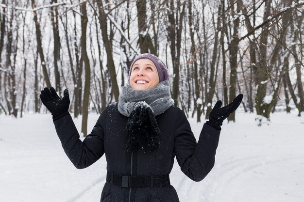 Porträt einer lächelnden hübschen Frau, die Spaß an der Wintersaison hat