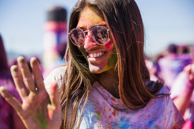 Porträt einer lächelnden jungen Frau, die im holi genießt