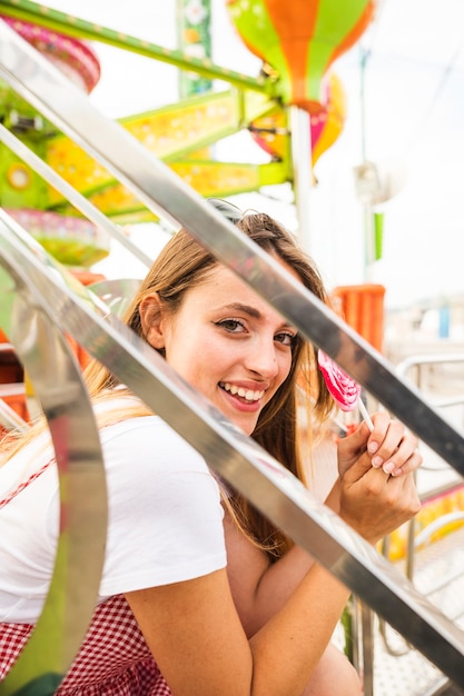 Porträt einer lächelnden jungen Frau, die Lutscher hält