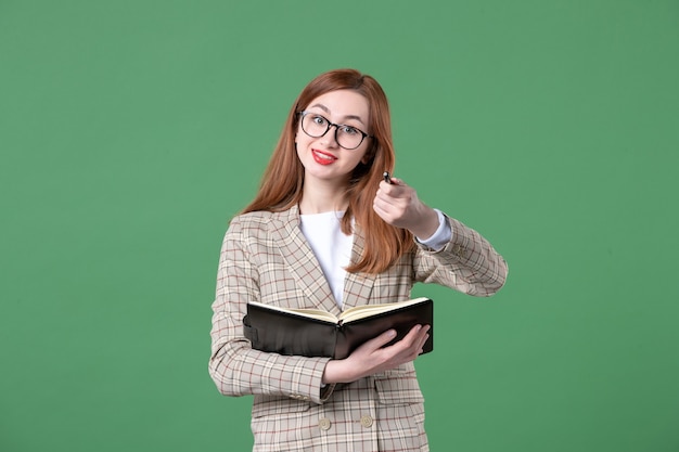 Porträt einer Lehrerin, die Notizen auf Grün aufschreibt