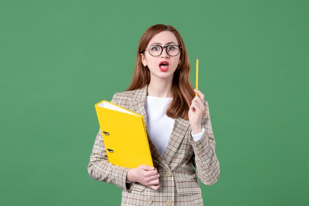 Porträt einer Lehrerin mit gelben Dateien auf Grün