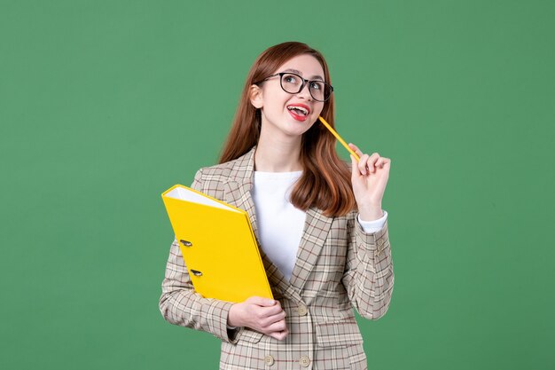 Porträt einer Lehrerin mit gelben Dateien auf Grün