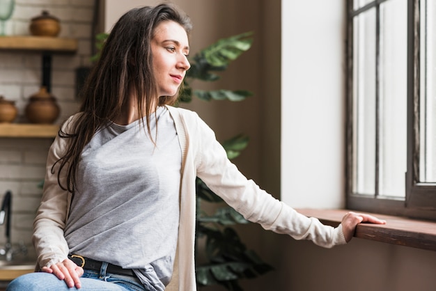 Porträt einer lesbischen Frau, die Fenster betrachtet