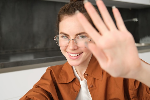 Kostenloses Foto porträt einer niedlichen freundin blockiert die kamera mit ausgestreckten händen bedeckt das gesicht und lächelt aufhören zu filmen