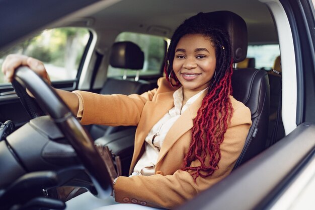 Porträt einer positiven afroamerikanischen Dame im Auto