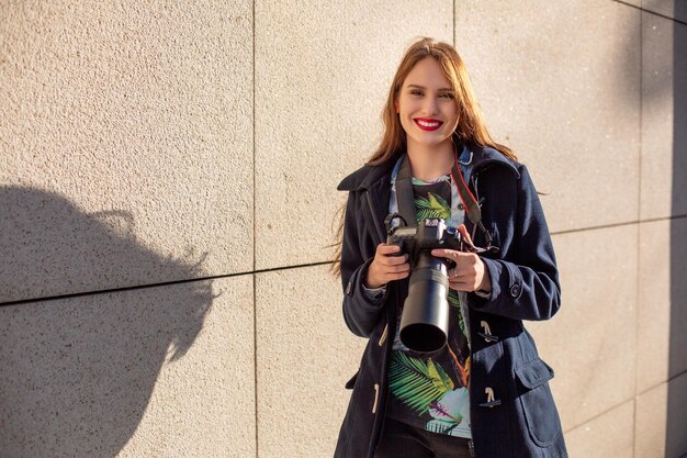 Porträt einer professionellen Fotografin auf der Straße, die mit einer Kamera fotografiert. Fotoshooting Fotoshooting in der Stadt