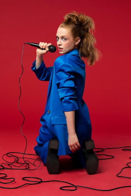 Kostenloses Foto porträt einer rothaarigen singenden frau mit mikrofon