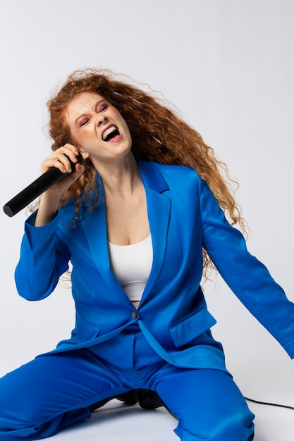 Porträt einer rothaarigen singenden Frau mit Mikrofon
