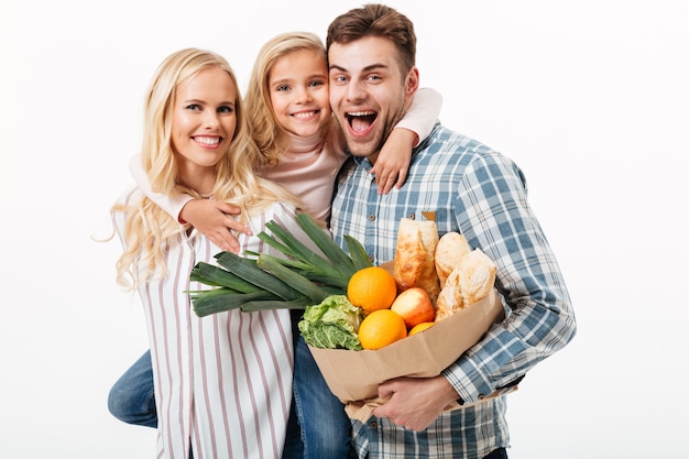 Porträt einer schönen Familie, die Papiereinkaufstasche hält