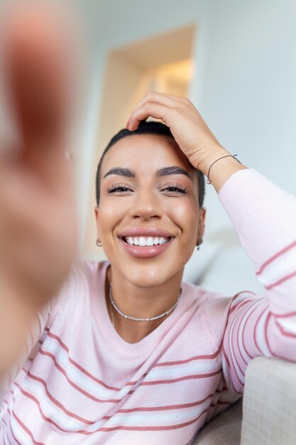 Porträt einer schönen Frau, die zu Hause lächelt Afroamerikanische Frau in lässigem Blick in die Kamera mit Kopierraum Fröhliches Mädchen gemischter Abstammung, das sich zu Hause mit großem Lachen entspannt