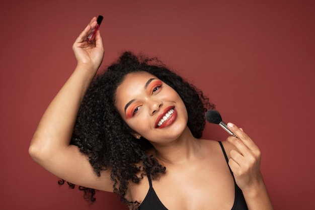Porträt einer schönen Frau mit Lippenstift und Make-up-Pinsel