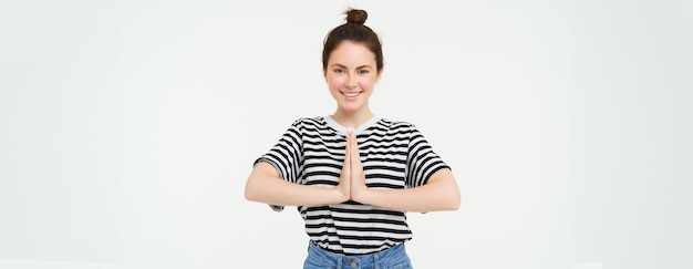 Kostenloses Foto porträt einer schönen jungen frau, die die hände zusammenhält, die namaste-geste sagt, danke, drückt sich aus