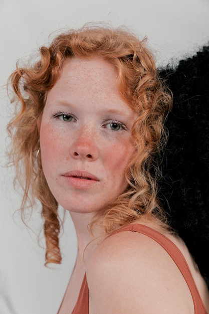 Porträt einer schönen jungen Frau, die ihren Kopf mit dem schwarzen Haar berührt