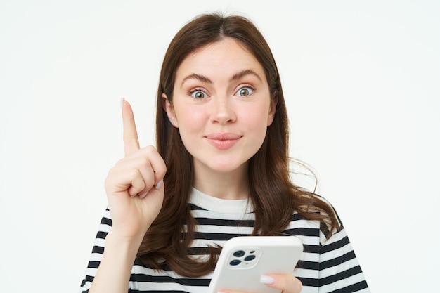 Porträt einer schönen jungen Frau hat eine Idee Vorschlag zeigt einen Finger und hält Smartphone