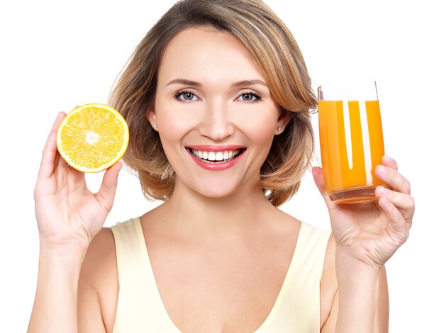 Porträt einer schönen jungen Frau mit einem Glas Saft und Orange lokalisiert auf Weiß.