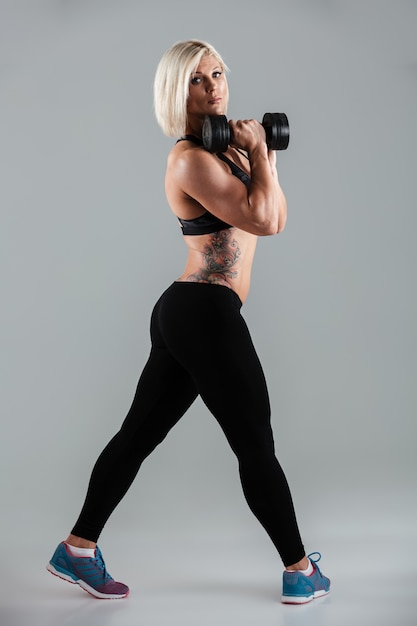 Porträt einer selbstbewussten muskulösen Sportlerin in voller Länge
