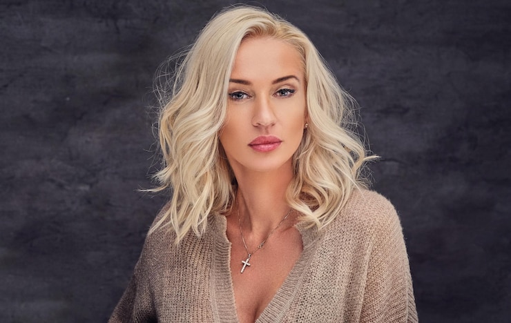 Kostenlose Foto porträt einer sexuellen blonden frau mit lockigem haar auf grauem hintergrund.