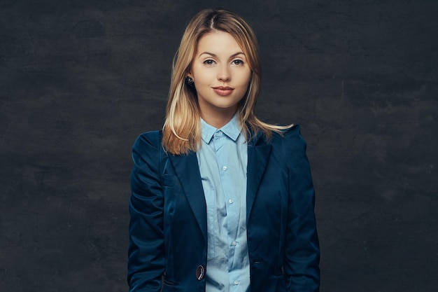 Kostenloses Foto porträt einer sinnlichen blonden geschäftsfrau, gekleidet in einen formellen anzug und ein blaues hemd. getrennt auf einem dunklen hintergrund.